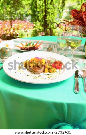 Gourmet lunch with fish and vegetables served in a garden restaurant