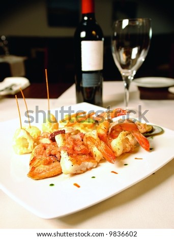 Fish fillet and jumbo shrimp dish with small potatoes