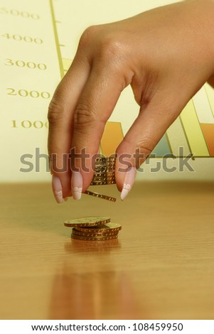 A hand picking up (or stacking up) some coins.