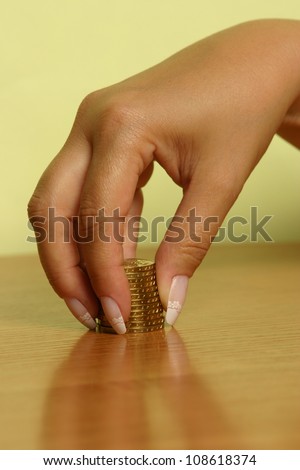 A hand picking up (or stacking up) some coins.