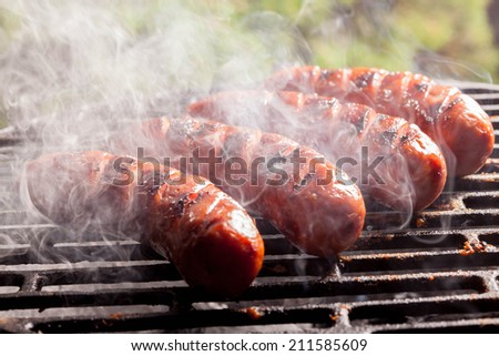 Grilling sausages on barbecue grill. Selective focus.
