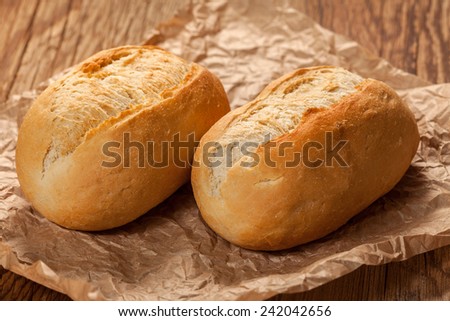 Freshly baked crusty rolls on old rustic wooden boards.