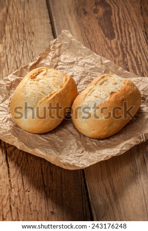 Freshly baked crusty rolls on old rustic wooden boards.