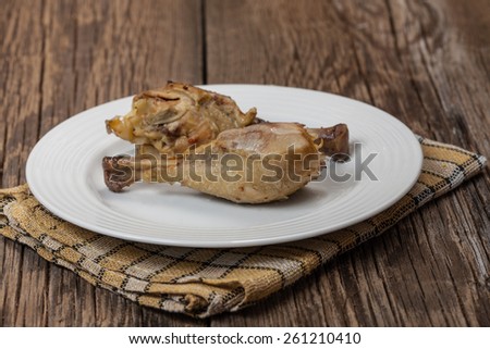 Cooked chicken sticks on a wooden table.