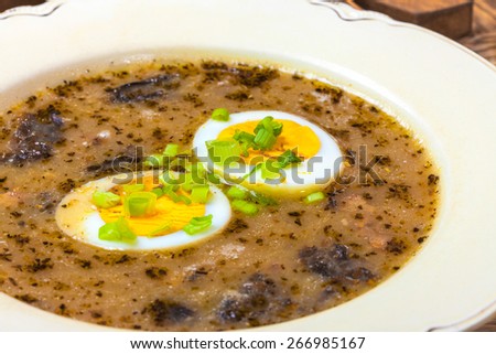Traditional Polish soup with egg and smoked. ?urek.