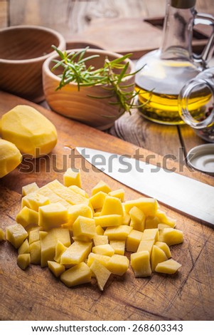 Peeled and diced potatoes on a wooden table.