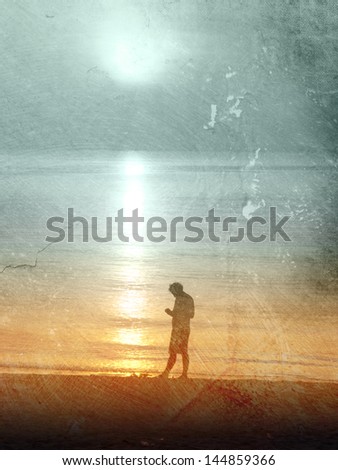 Sad man standing at the beach at sunset