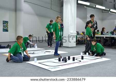 SOCHI, RUSSIA - November 21, 2014: Schoolchildren with robot on the playing field during Robofest, a part of World Robot Olympiad Russia 2014. It was attended by delegates from 47 countries
