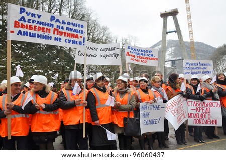 SOCHI, RUSSIA - FEBRUARY 15:Construction workers hold posters and headers with slogans in support of Vladimir Putin on presidential elections of the Russian Federation on February 15, 2012 in Sochi.