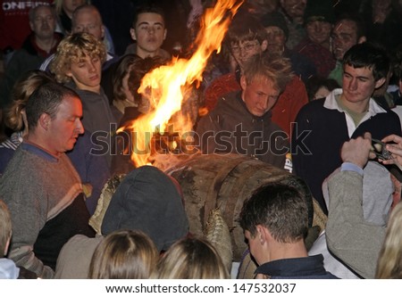 OTTERY ST MARY, GREAT BRITAIN - NOVEMBER 5: An unidentified barrel roller with burning tar barrel running through the crowd at 2007 Tar Barrels of Ottery Carnival on November 5, 2007 in Ottery St Mary