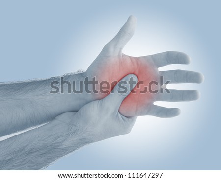 Acute pain in a man palm. Male holding hand to spot of palm-ache. Concept photo with Color Enhanced blue skin with read spot indicating location of the pain.