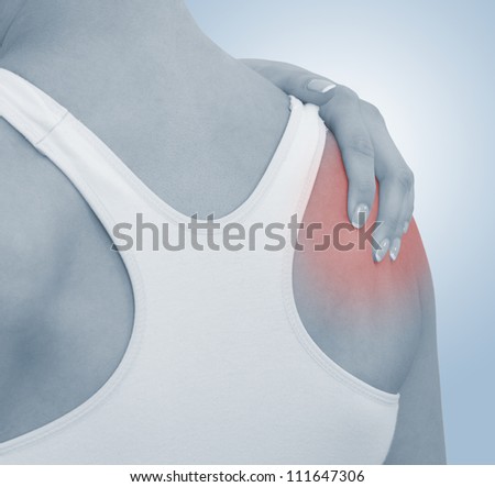 Acute pain in a woman shoulder. Female holding hand to spot of shoulder-aches. Concept photo with Color Enhanced blue skin with read spot indicating location of the pain.