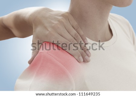 Acute pain in a woman shoulder. Female holding hand to spot of shoulder-aches. Concept photo with Color Enhanced skin with read spot indicating location of the pain.