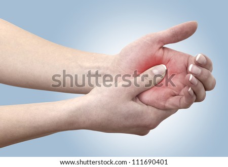 Acute pain in a woman palm. Concept photo with Color Enhanced skin with read spot indicating location of the pain.