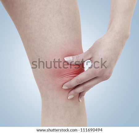 Acute pain in a woman knee. Concept photo with Color Enhanced blue skin with read spot indicating location of the pain.