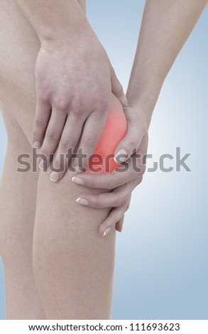 Acute pain in a woman knee. Concept photo with Color Enhanced skin with read spot indicating location of the pain.