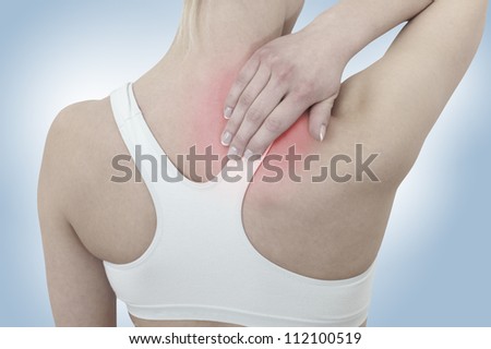 Acute pain in a woman neck. Female holding hand to spot of neck-aches. Concept photo with Color Enhanced skin with read spot indicating location of the pain.