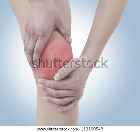 Acute pain in a woman  knee. Female holding hand to spot of knee-aches. Concept photo with Color Enhanced skin with read spot indicating location of the pain.