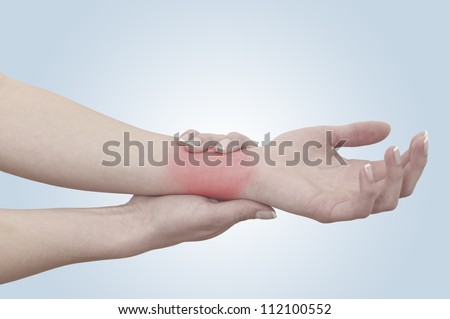 Acute pain in a woman wrist. Female holding hand to spot of wrist pain. Concept photo with Color Enhanced skin with read spot indicating location of the pain.