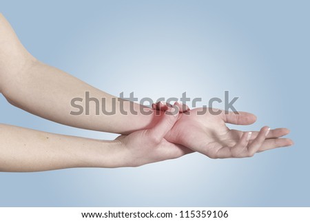 Acute pain in a woman wrist. Female holding hand to spot of wrist pain. Concept photo with Color Enhanced skin with read spot indicating location of the pain. Isolation on a white background.