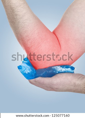 Male holding ice gel pack on elbow. Medical concept photo. Color Enhanced skin with read spot indicating location of the pain.