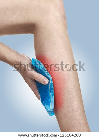 Cool gel pack on a swollen hurting calf. Medical concept photo. Isolation on a white background. Color Enhanced skin with read spot indicating location of the pain.