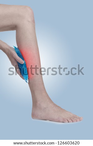 Cool ice on a swollen hurting leg. Medical concept photo. Isolation on a white background. Color Enhanced skin with read spot indicating location of the pain.