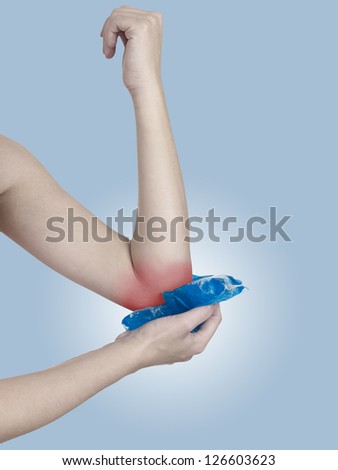 Cool gel pack on a swollen hurting elbow. Medical concept photo. Color Enhanced skin with read spot indicating location of the pain.