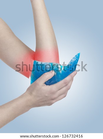 Cool ice on a swollen hurting elbow. Medical concept photo.  Color Enhanced skin with read spot indicating location of the pain.