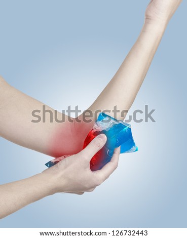 Cool ice on a swollen hurting elbow. Medical concept photo. Color Enhanced skin with read spot indicating location of the pain.
