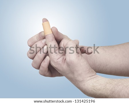 Healing plaster on finger. Pain concept photo.