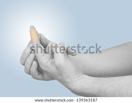 Putting a small adhesive plaster on a finger.  Concept photo with Color Enhanced skin.