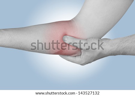 Acute pain in a man elbow. Male holding hand to spot of elbow pain.