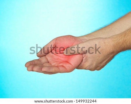 Acute pain in palm of hand. Male holding hand to spot of palm-ache.