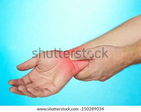 Wrist pain. Male holding hand to spot of wrist pain.