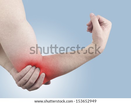 Pain in a man elbow. Male holding hand to spot of elbow pain.