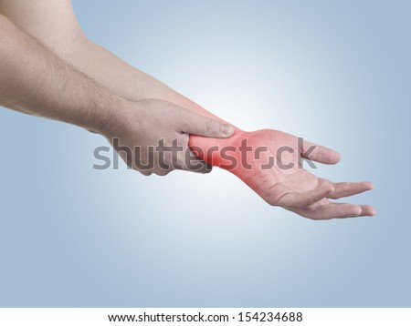 Pain in a man wrist. Male holding hand to spot of wrist pain.