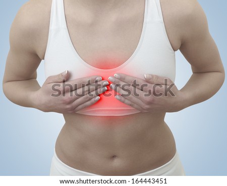 Acute pain in a woman chest. Female holding hand to spot of chest-ache.