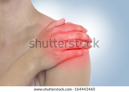 Acute pain in a woman back. Female from behind holding hand to spot of back pain. Concept photo with Color Enhanced skin with read spot indicating location of the pain.
