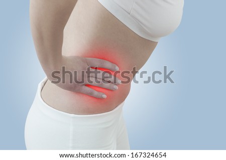 Acute pain in a woman abdomen. Female holding hand to spot of Abdomen-ache. Concept photo with Color Enhanced skin with read spot indicating location of the pain.