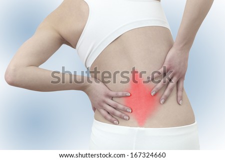 Acute pain in a woman back. Female from behind holding hand to spot of back pain. Concept photo with Color Enhanced skin with read spot indicating location of the pain.