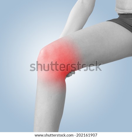 Acute pain in a knee. Female holding hand to spot of knee-aches.