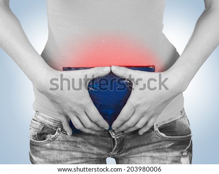 Acute pain in a woman stomach. Woman holding hand to spot of stomach.