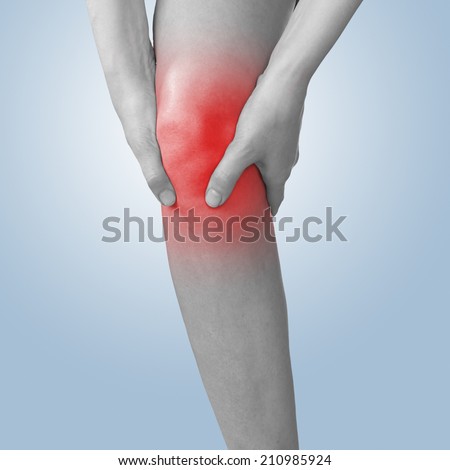 Acute pain in a man  knee. Male holding hand to spot of knee-aches. Concept photo with Color Enhanced blue skin with read spot indicating location of the pain. Isolation on a white background.