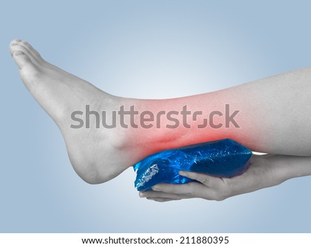 Acute pain in a woman ankle. Woman holding hand to spot of ankle-aches.