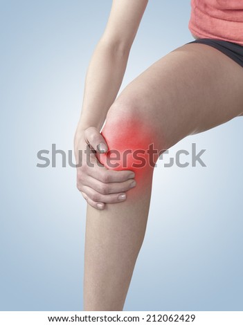 Pain in a woman knee. Woman hand to spot of knee pain.