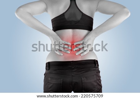 Back pain. Athletic woman in black sportswear standing and rubbing the muscles of her lower back, cropped torso portrait.