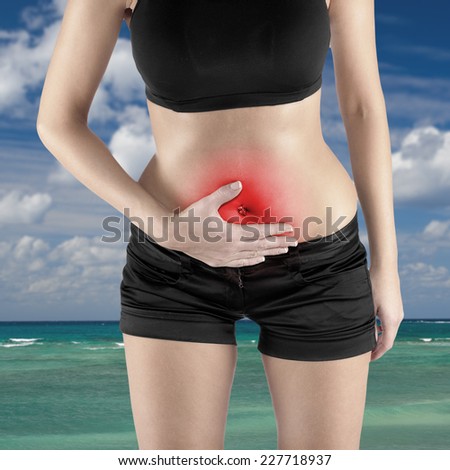 Woman\'s hands on stomach pain concept.