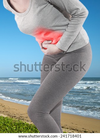 Woman with both palm around waistline to show pain and injury on belly area.