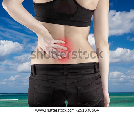 Woman with both palm around back to show pain and injury on back area. Medical health care concept.
